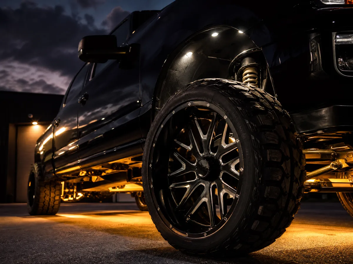 Custom wheel and underbody lighting on a black pickup truck